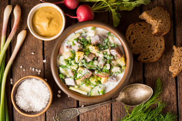 Wall Mural - Okroshka. Traditional Russian summer cold yogurt soup in bowl on wooden background.