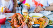Macro closeup of lobsters and seafood on plate with tartar sauce and garlic butter