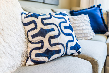 Closeup of new modern blue couch sofa by windows with natural light and pillows