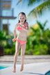 © travnikovstudio - Little happy girl enjoy vacation near outdoor swimming pool