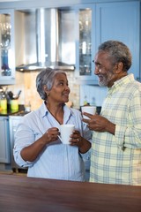 Wall Mural - Couple looking at each other while standing in kitchen