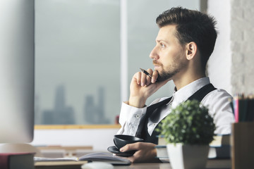 Canvas Print - Handsome guy drinking coffee at workplace