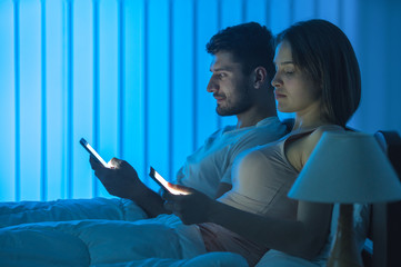 Wall Mural - The couple phone in the bed. night time, full grip focus