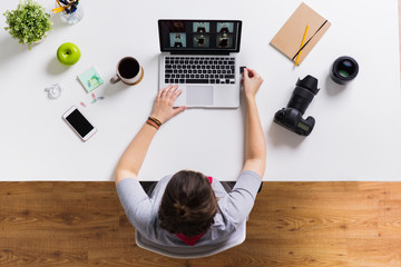 Wall Mural - woman with camera flash drive and laptop at table