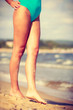 © Voyagerix - Woman walking on beach wearing swimsuit