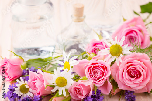 Spa still life - Ätherisches Öl in Glasflasche mit Rosen, Lavendel und Kamille