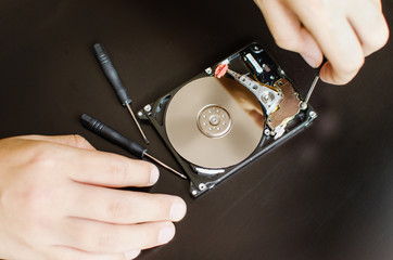 Repair of the dismantled hard drive. Hdd with mirror effect. Screwdrivers for computer repair.