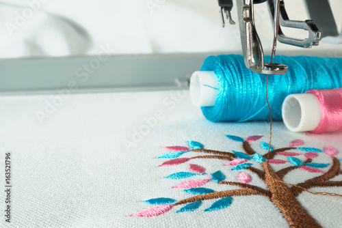 Cuadros en Lienzo Picture of workspace in the embroidery machine close up look under the needle, lovely tree minimal sytle on background have two colorfull thread cyan and pink