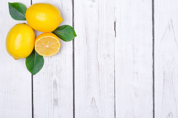 Fresh lemons on a wooden table top view with copy space.