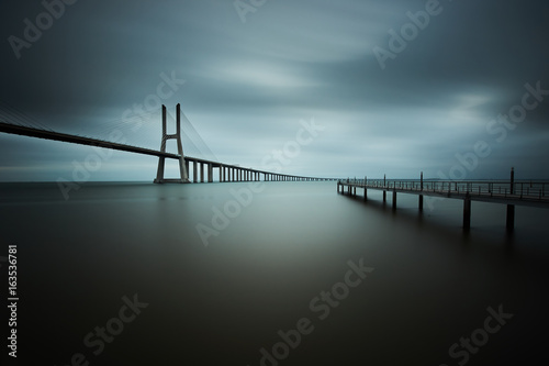 фотография vasco da gama bridge in lisbon on a cloudy day