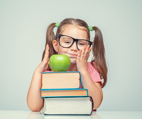 Wall Mural - bored beautiful cute little girl with green apple and thick books