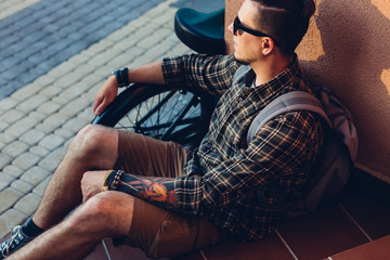 Wall Mural - Young Man In Sunglasses Rests On Steps Next To Bicycle Holiday Activity Resting Concept