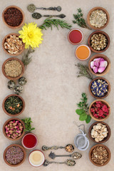 Poster - Herb tea selection forming an abstract background with strainer, oriental tea cups and old spoons on natural hemp paper. Teas used in natural alternative medicine.