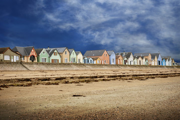 Row of Gran Hameau des Dunes. Colorful houses on the beach.  Cotentin. Normandy. France.