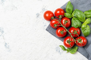 Fresh cherry tomatoes with basil leaves, top view with copy space