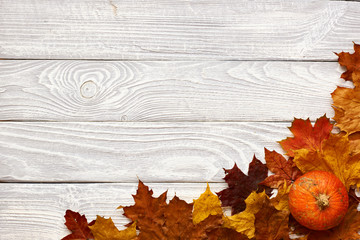 Sticker - Autumn leaves and pumpkins over old wooden background