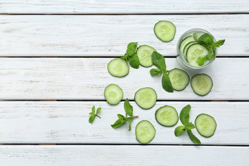 Wall Mural - Glass of delicious cucumber lemonade on wooden background