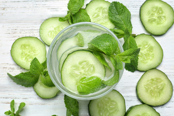 Wall Mural - Glass of delicious cucumber lemonade on wooden background