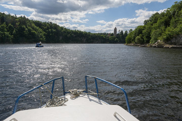 Two ships sailing across the lake heading for the old castle on the coast