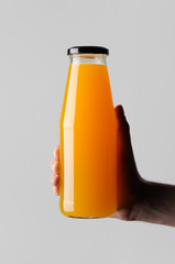 Sticker - Juice Bottle Mock-Up - Male hands holding a juice bottle on a gray background