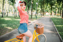 Pinup Girl On Retro Bicycle With Backet Of Flowers