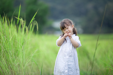 Happy cute little girl outdoors in summer day