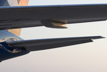 Tail Wing Of The Aircraft In The Light Of The Setting Sun, View From Under The Main Wing