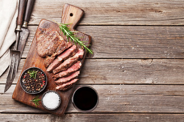 Wall Mural - Grilled beef steak with spices on cutting board