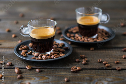 Fotomural Two cups of espresso and coffee beans on a wooden table