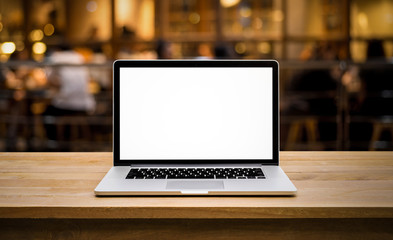 Wall Mural - Modern computer,laptop with blank screen on table with blur cafe,restaurant background