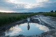 © shapovalphoto - girl and big puddle on a country road