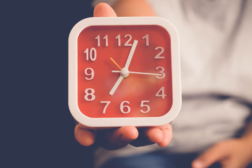 hand holding Alarm clock with filter effect retro vintage style