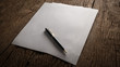 © Johnstocker - Blank sheet of paper and pen on wooden table.