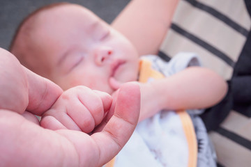 Baby hand holding adult hand