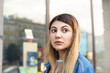 © shurkin_son - Attractive mixed race young woman with long bleached hair, brown eyes and facial piercing, standing on city streets, waiting for friends for a walk, looking aside with serious expression on her face