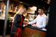 © Connect Images - Waiter touching young woman's hand at restaurant counter