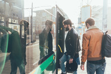Two Young Men Boarding Tram  At City Tram Station