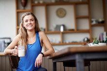 Young Woman At Kitchen Table With Smoothie