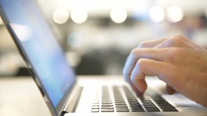 Handsome man in suit work using laptop computer in the office. businessman is typing message by keypad. Male use portable laptop and communicate online sitting at the table. digital gadgets close up