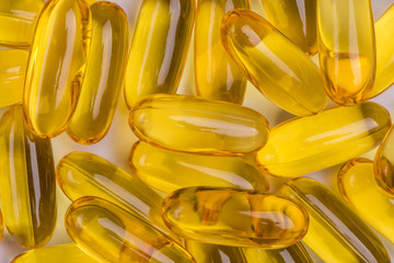 Yellow soft gelatin capsules common use in pharmaceutical manufacturing industry, extract natural essential oil supplements.
