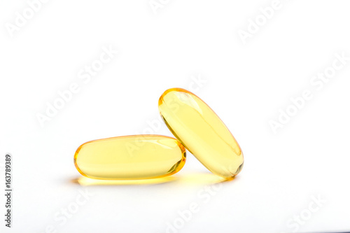 Fotografie, Obraz Two yellow soft gelatin capsules contain of fish oil supplement, isolated on white background