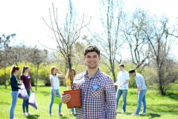 Canvas Print - Handsome young volunteer with team outdoors