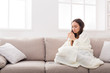 © Prostock-studio - Cozy home. Girl in a plaid on the couch