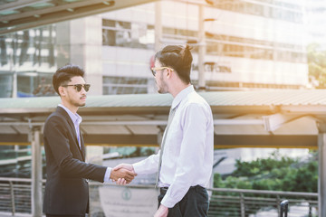 Wall Mural - Business handshake concept. shaking hand of two businessman negotiation closing a deal city background