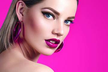 Wall Mural - a beautiful, sweet, well-groomed girl on a bright pink background with combed smooth hair and large 