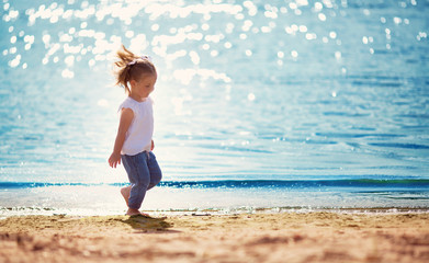 Wall Mural - two years old girl running at the sea