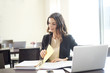 © gzorgz - Doing some paperwork at office. Shot of a young professional woman sitting at desk in front of laptop and working on business conctract.