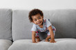 © Lisa Tichané - smiling toddler crouching on couch
