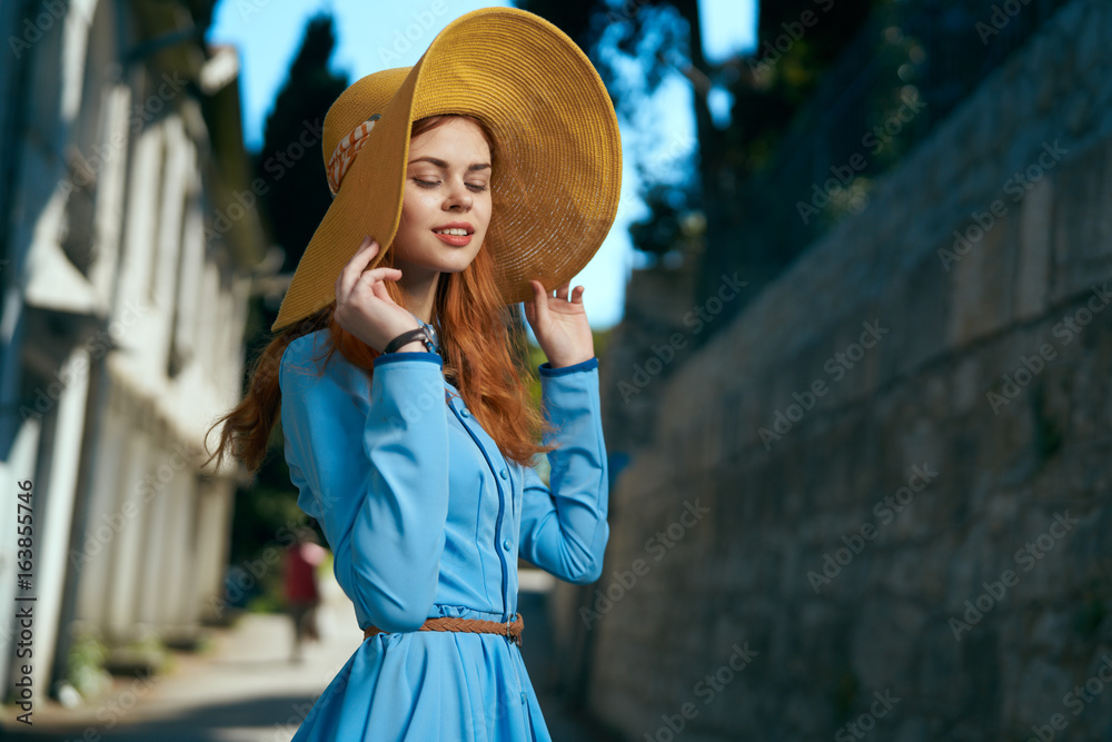 Stock-Foto „Beautiful young woman in a blue dress walking along the ...