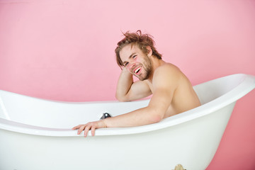 Wall Mural - guy with muscular body sitting in white bathtub